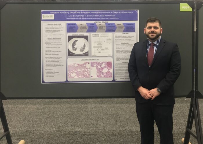 Dr. Aaron Brooks standing with presentation